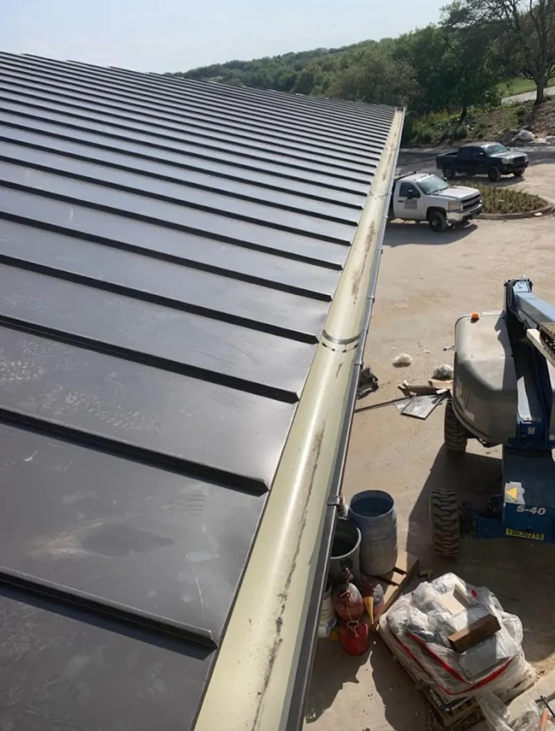 Standing seam panel and gutter detail on a metal roofing jobsite in Green Oak